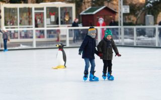 Winters tafereel: kinderen schaatsen op het ijs