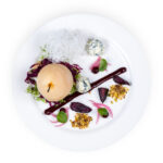 Gepocheerde Nashipeer, rode kool, blauwe kaas, noten, een crème van rode biet, paarse wortel, ingelegde uitjes en een nestje van glasnoedels