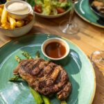 Ribeye (dry aged) van Simmetaler rund, gegrilde groene asperges en groene salade met jus de veau