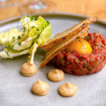 Steak tartaar met ei, bacon, mayonaise, tuinkers en zuurdesembrood